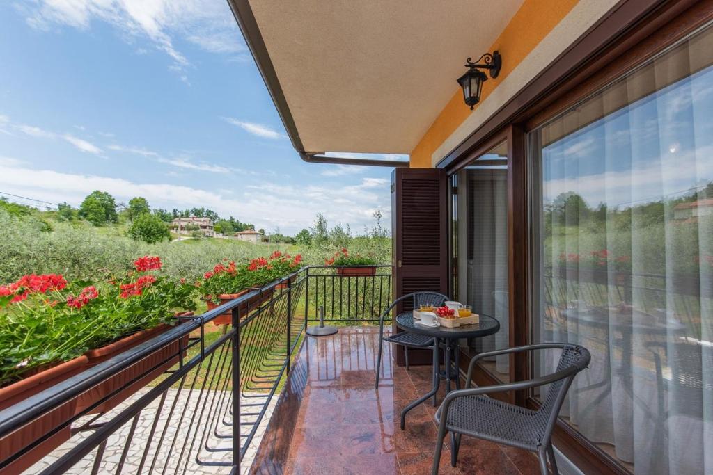 a balcony with a table and chairs and flowers at Apartment Luma in Vižinada