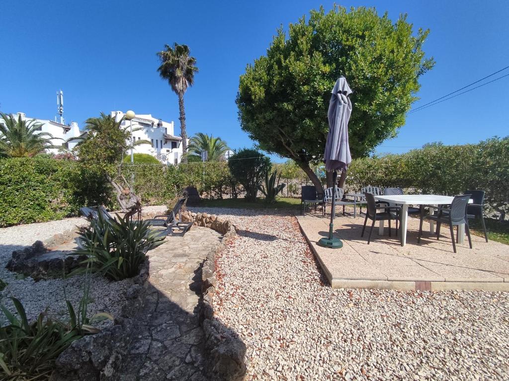 eine Terrasse mit einem Tisch und einem Sonnenschirm in der Unterkunft 6 Mourisca - Casas & Papéis in Lagoa