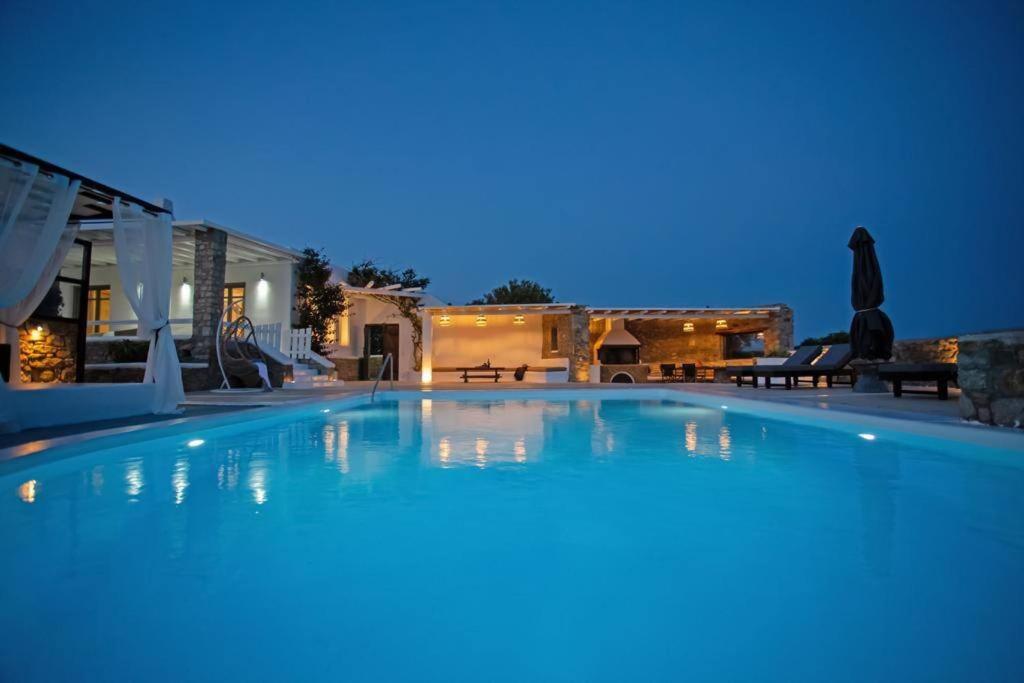 a large blue swimming pool at night at Villabellum Mykonos in Mýkonos City