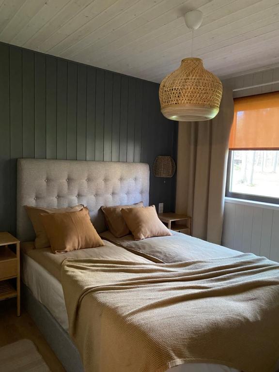a bedroom with a large bed with a large headboard at Valgeranna Puhkekeskus in Valgeranna