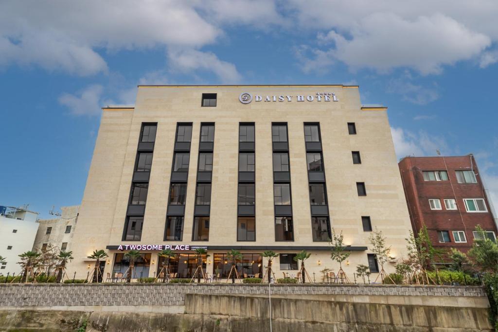 a building with a sign on the side of it at Masan Daisy Hotel in Changwon