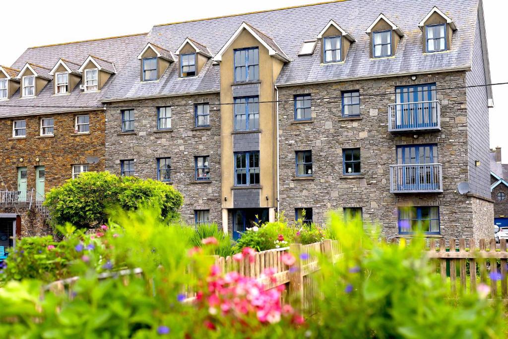 - un grand bâtiment en briques avec des fenêtres et des fleurs devant dans l'établissement Long Quay Apartments, Clonakilty, à Clonakilty