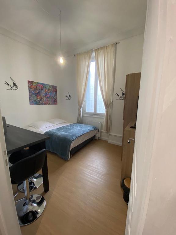 une chambre avec un lit, un bureau et une fenêtre dans l'établissement Superbe appartement centre ville chez Tony, à Périgueux