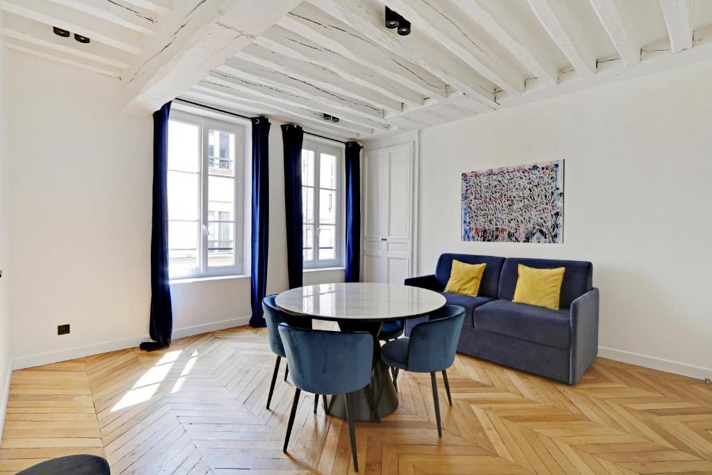 Pick A Flat's Apartment in Jardin du Luxembourg - Rue Royer Collard في باريس: غرفة معيشة مع طاولة وأريكة