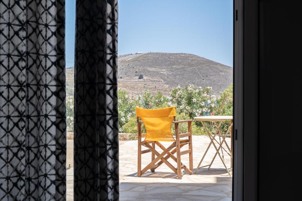 a yellow chair sitting on a porch with a table at Casa Fabrica in Ano Syros