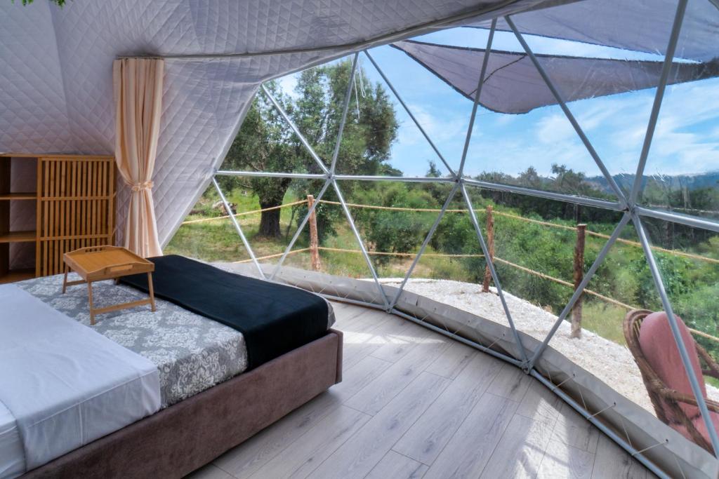 a bedroom with a bed in a tent with a view at luxury dome tents ikaria ap'esso2 in Raches