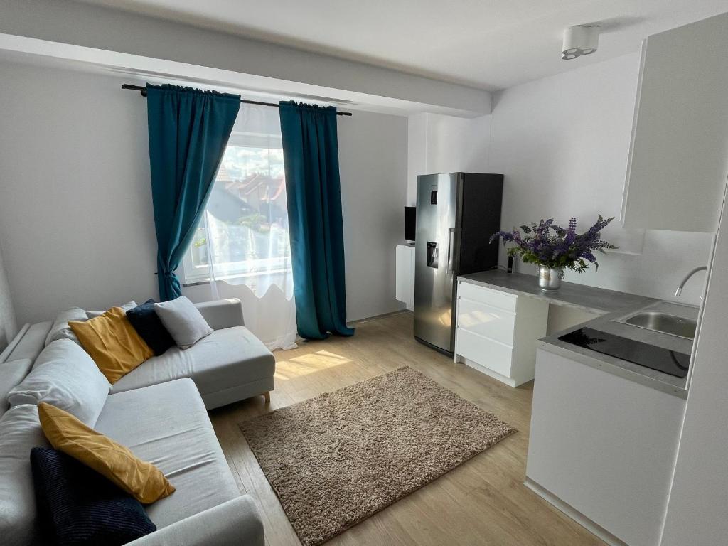 a living room with a couch and a kitchen at Arenaapartments in Gdańsk