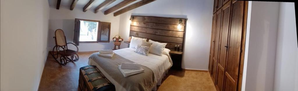 a bedroom with a large bed with a wooden headboard at El Rincón de BeBa in Segura de la Sierra