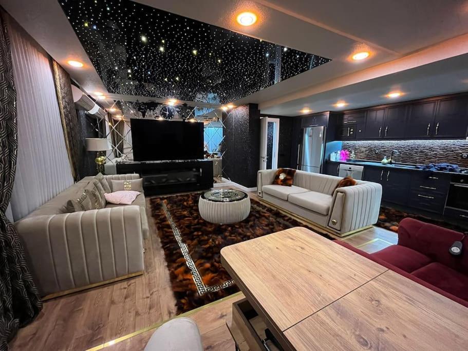 sala de estar con 2 sofás y TV de pantalla plana en Квартира Versace 3+1 в Анталии en Hurmaköy