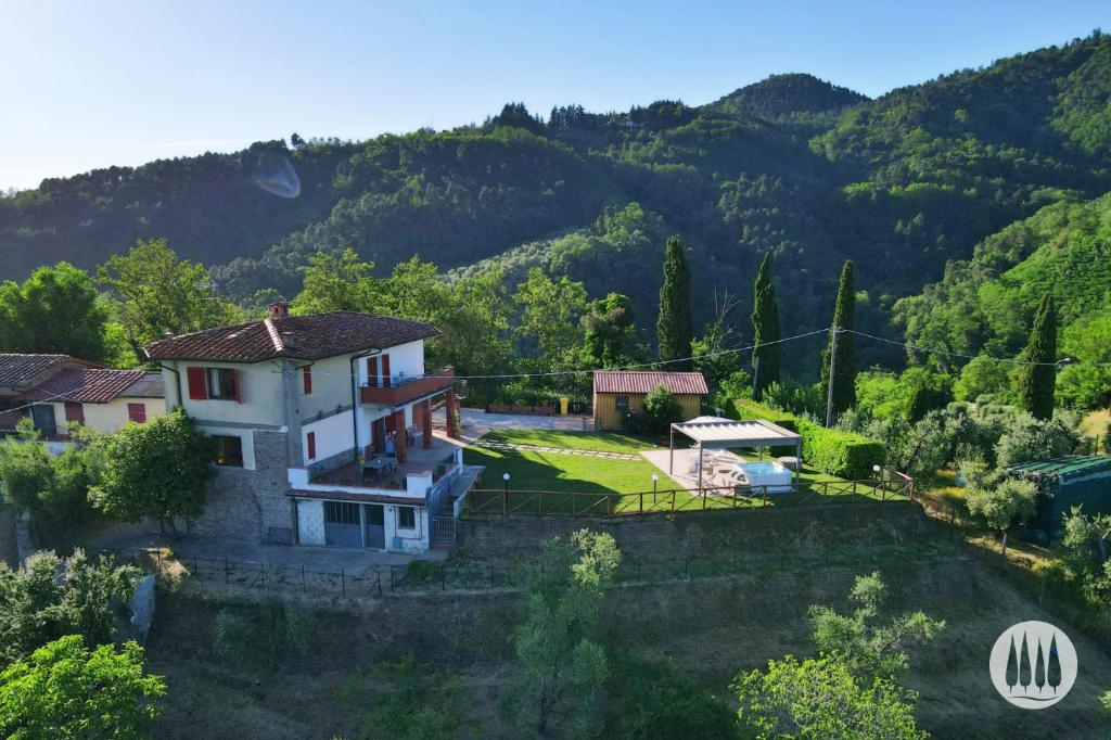 an aerial view of a house with mountains in the background at Agriturismo Irto Colle in Massa e Cozzile