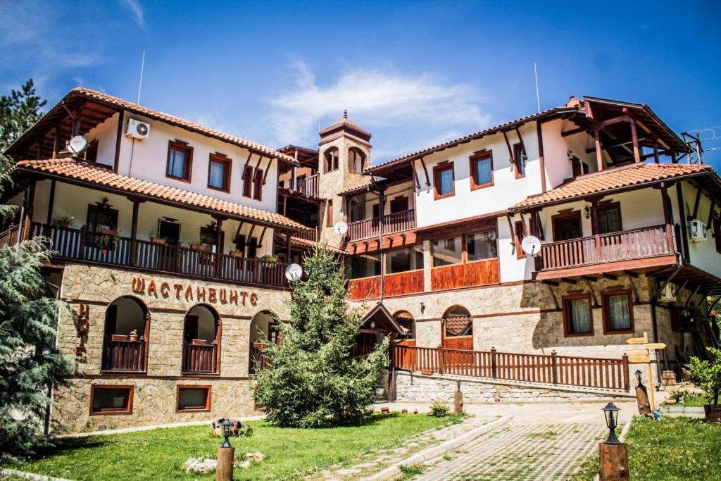 a large building with a sign on the side of it at комплекс Щастливците in Starozagorski Bani