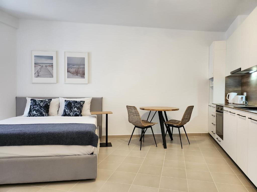 een slaapkamer met een bed en een tafel met stoelen bij ELISOS Studio Apartment with swimming pool in Vlorë