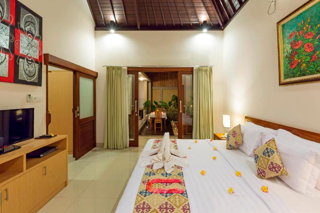 a bedroom with a bed and a television in a room at Kubal Villa and Living Seminyak in Canggu