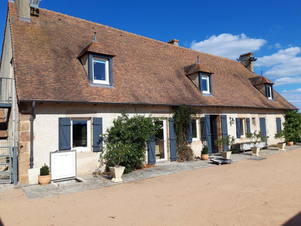 ein großes weißes Gebäude mit braunem Dach in der Unterkunft La ferme du Riau in Aurouer