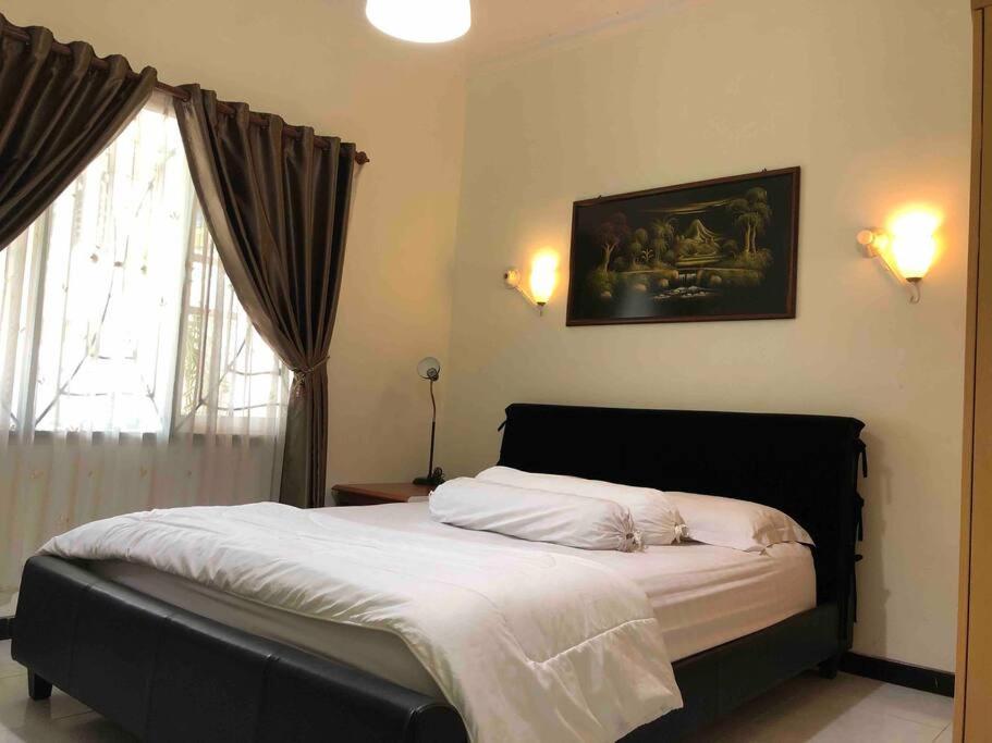 - une chambre avec un grand lit en face d'une fenêtre dans l'établissement Mitra@Guesthouse b29, à Batam Center