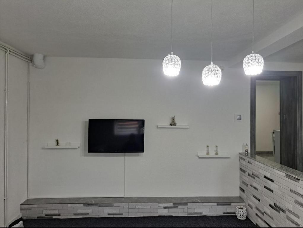 - un salon avec une télévision sur un mur blanc dans l'établissement Apartman Ivo, à Livno