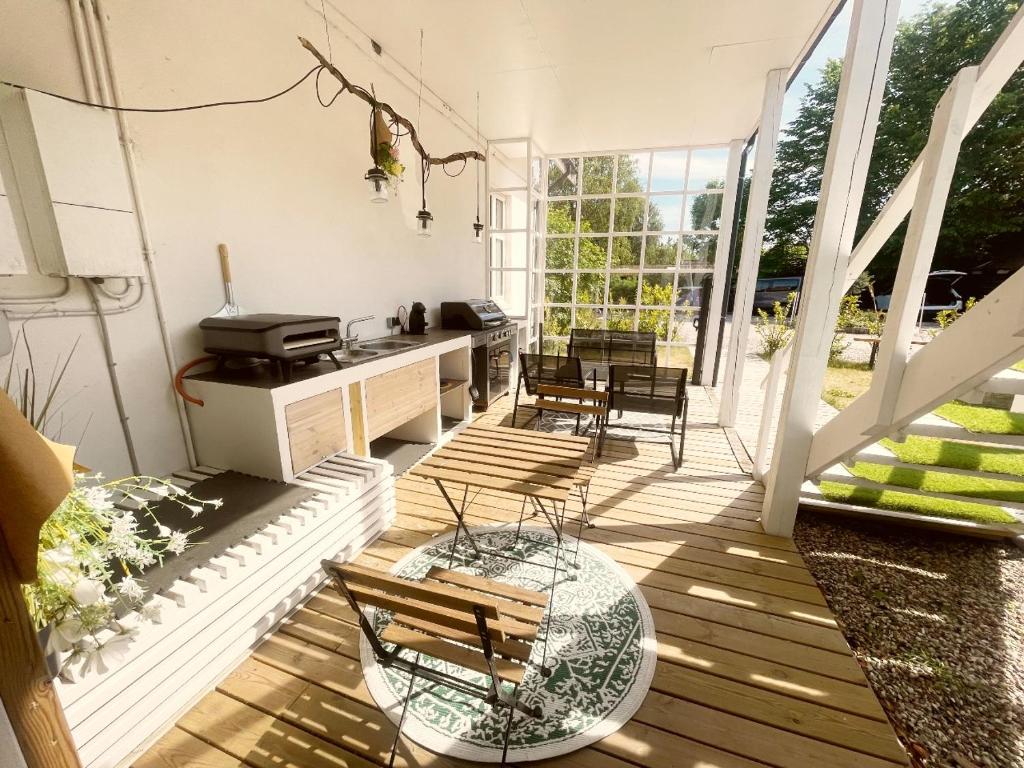 un porche cubierto con mesa y sillas en Sunny 1st floor apartment, en Tisvildeleje