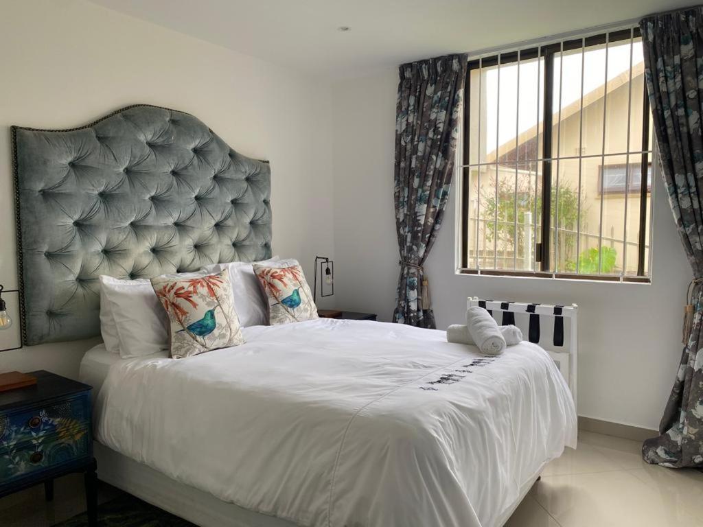 a bedroom with a large bed with a large headboard at Simla Luxury Apartments in Margate