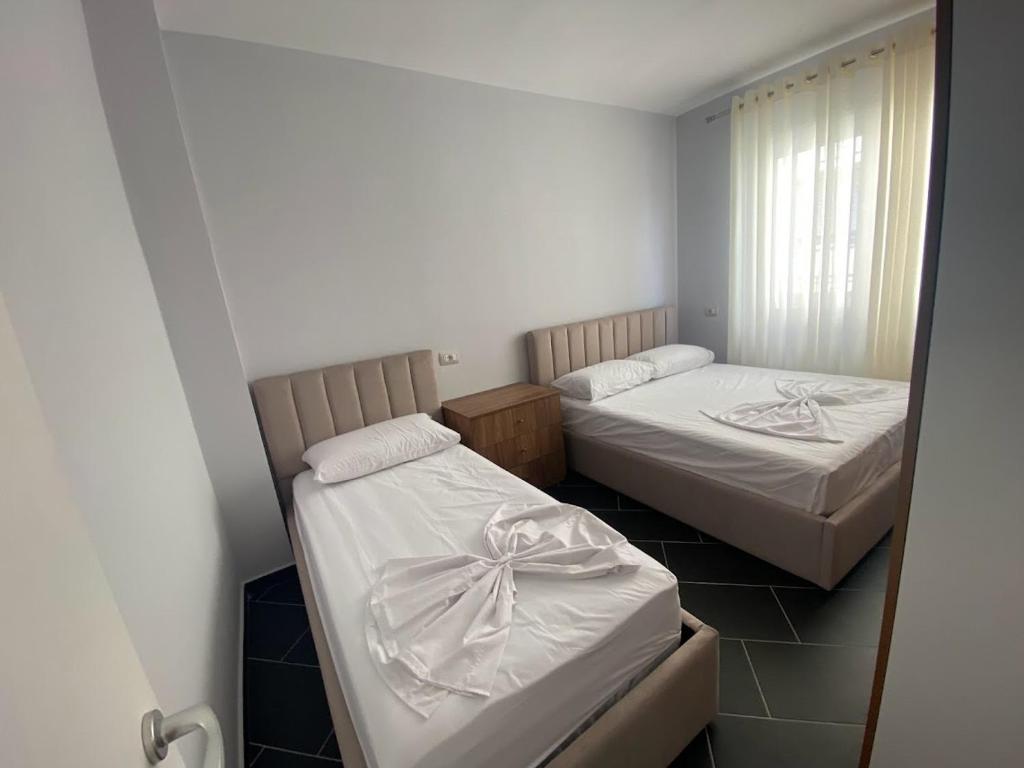 - une chambre avec 2 lits et un miroir dans l'établissement A&T Apartments, à Durrës
