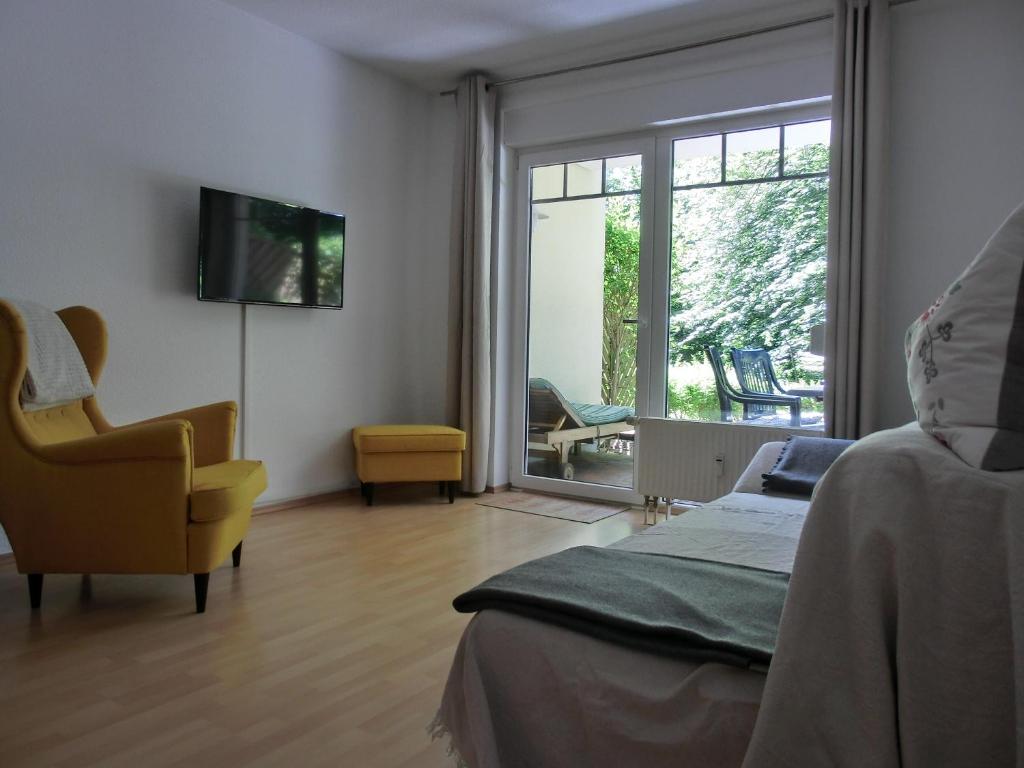 een slaapkamer met een bed, een stoel en een raam bij Ferienwohnung H 25 "Tausendschön" in Graal-Müritz
