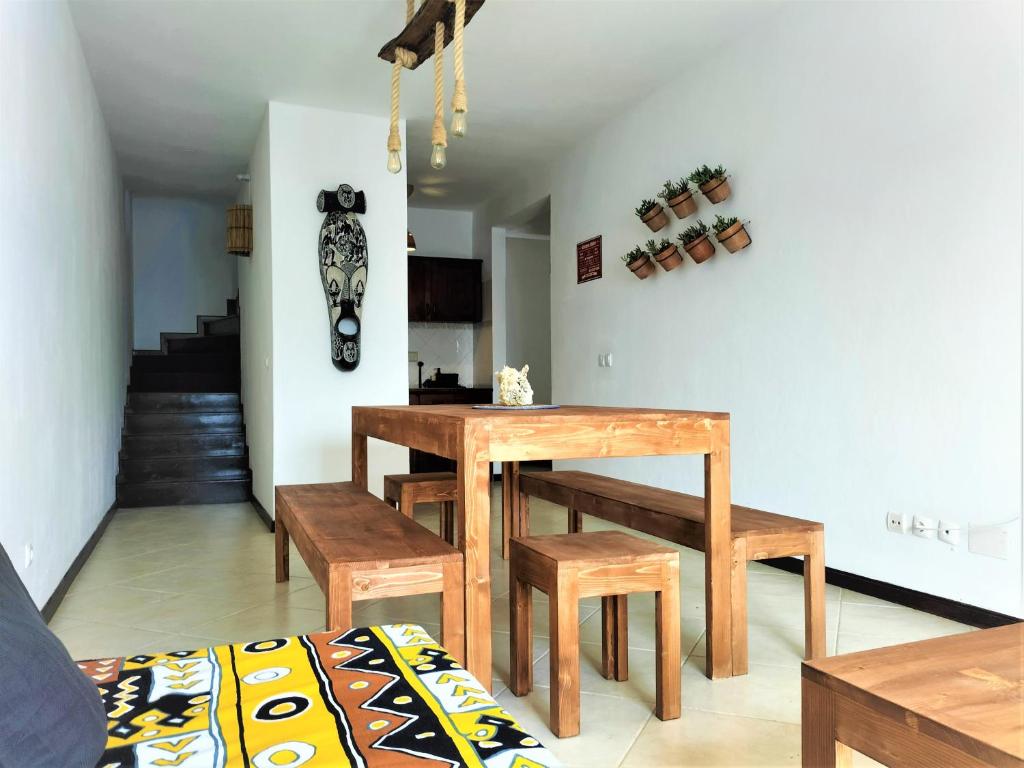 een eetkamer met een houten tafel en banken bij Solstice in Santa Maria