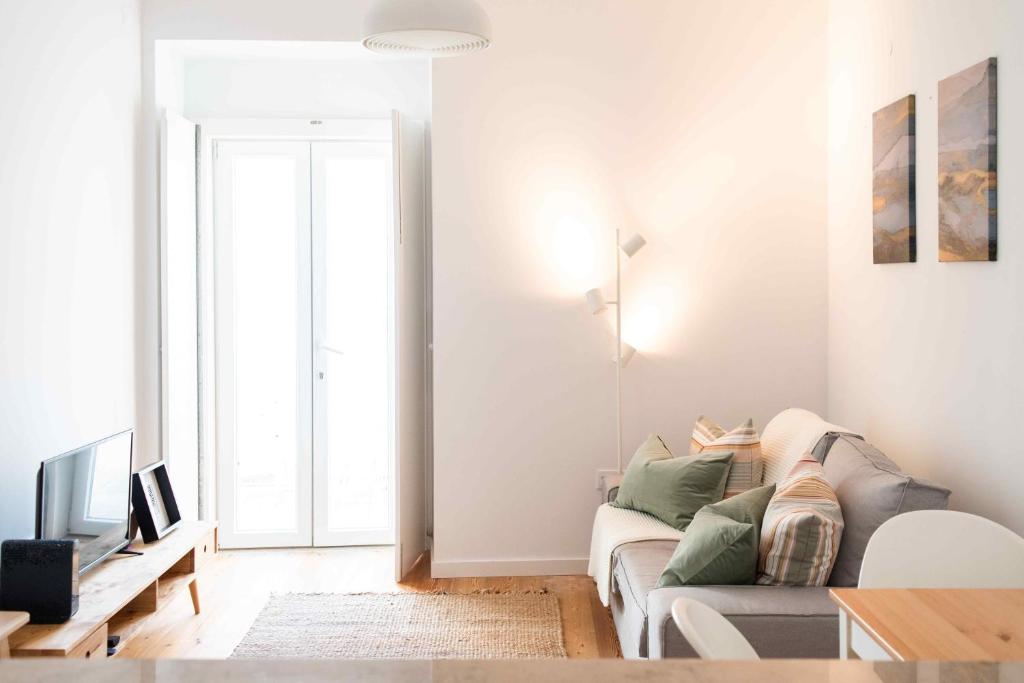 a white living room with a couch and a table at Amaro - Elegant 2 bedroom apartment in Alcantara in Lisbon