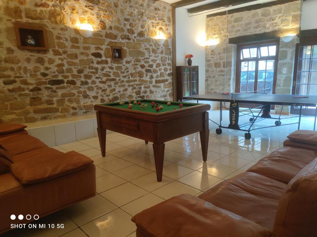 uma sala de estar com uma mesa de bilhar e mesas de pingue-pongue em Les colombages bis em Pazayac