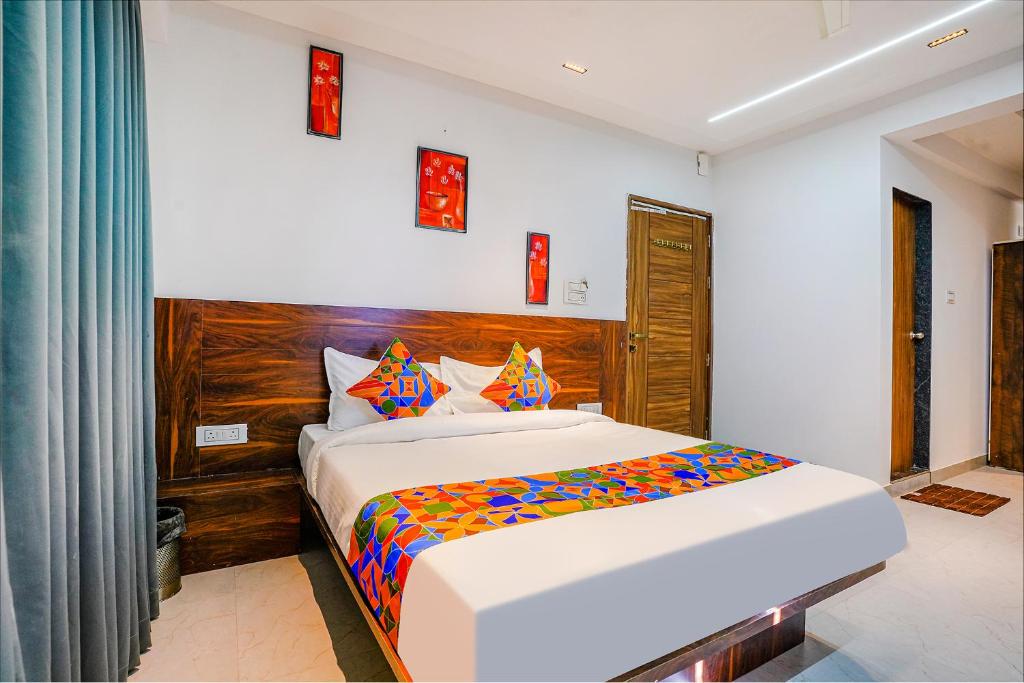 a bedroom with a large white bed with colorful sheets at Via Crystal Inn in Pune