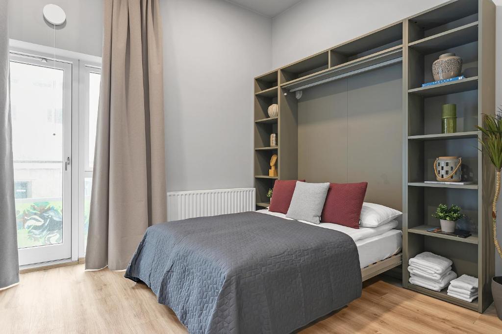 a bedroom with a bed and a book shelf at Cozy Studio Apartment in Reykjavík