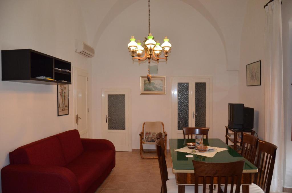 ein Wohnzimmer mit einem roten Sofa und einem Tisch in der Unterkunft Dalnonnolele Casa Vacanze in Mesagne