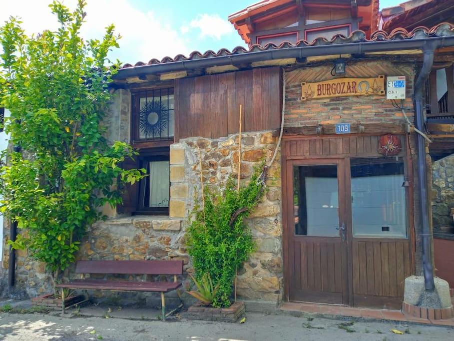 un edificio con un banco delante de él en Descanso en Burgozarre, en Mungia