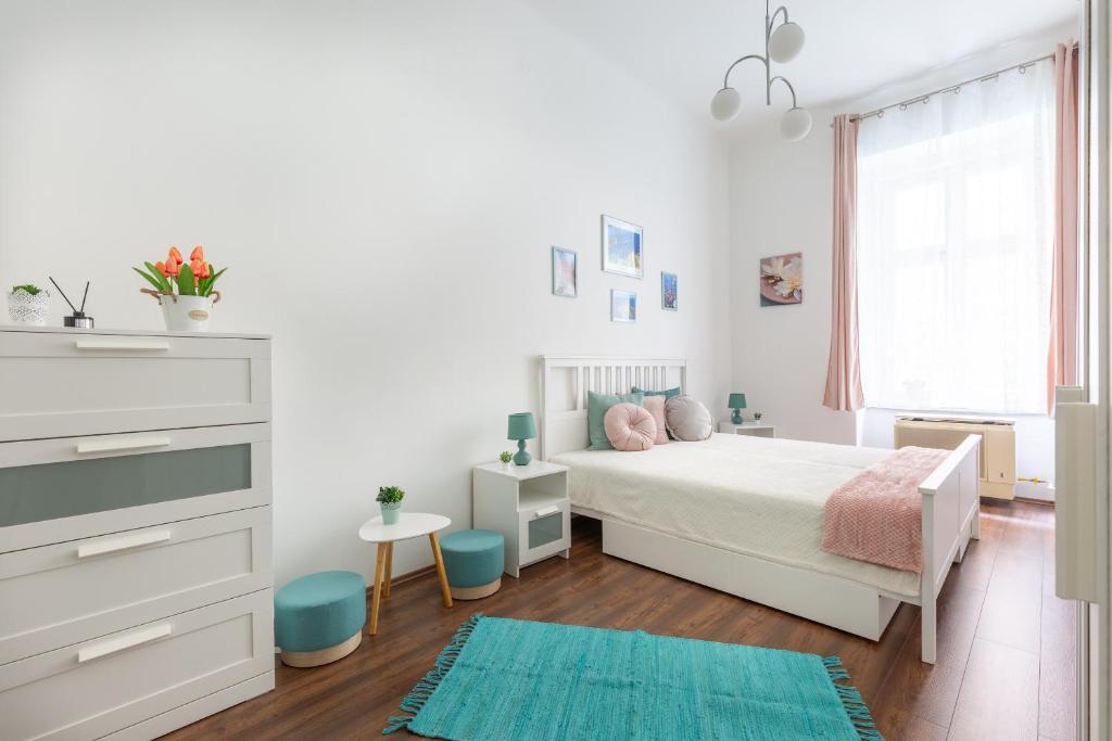 una camera bianca con un letto bianco e un tappeto blu di SZ63 Szondi Apartment a Budapest