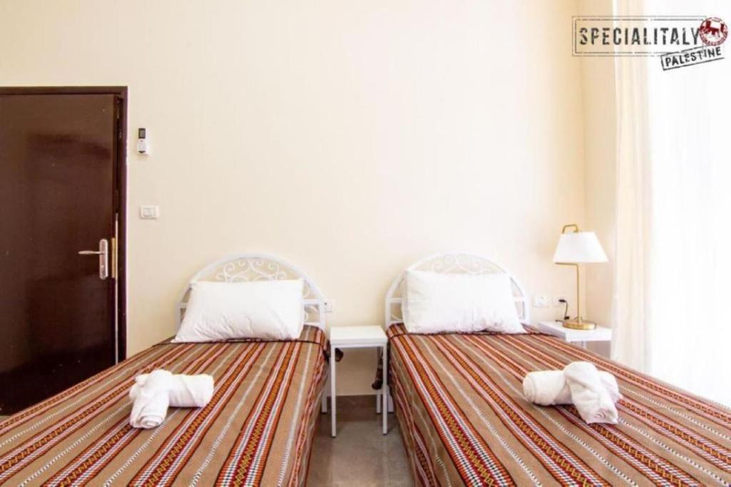 two beds sitting next to each other in a room at Mary's Guest House in Bethlehem