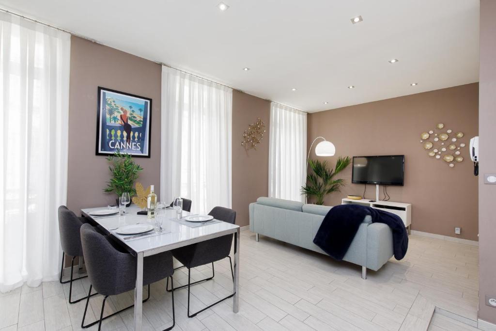 a living room with a table and a couch at beautiful 3 room-flat near palais in Cannes