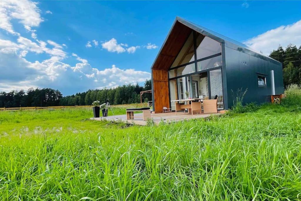 a small house in a field of grass at PAPIERÓWKA in Dźwierzuty