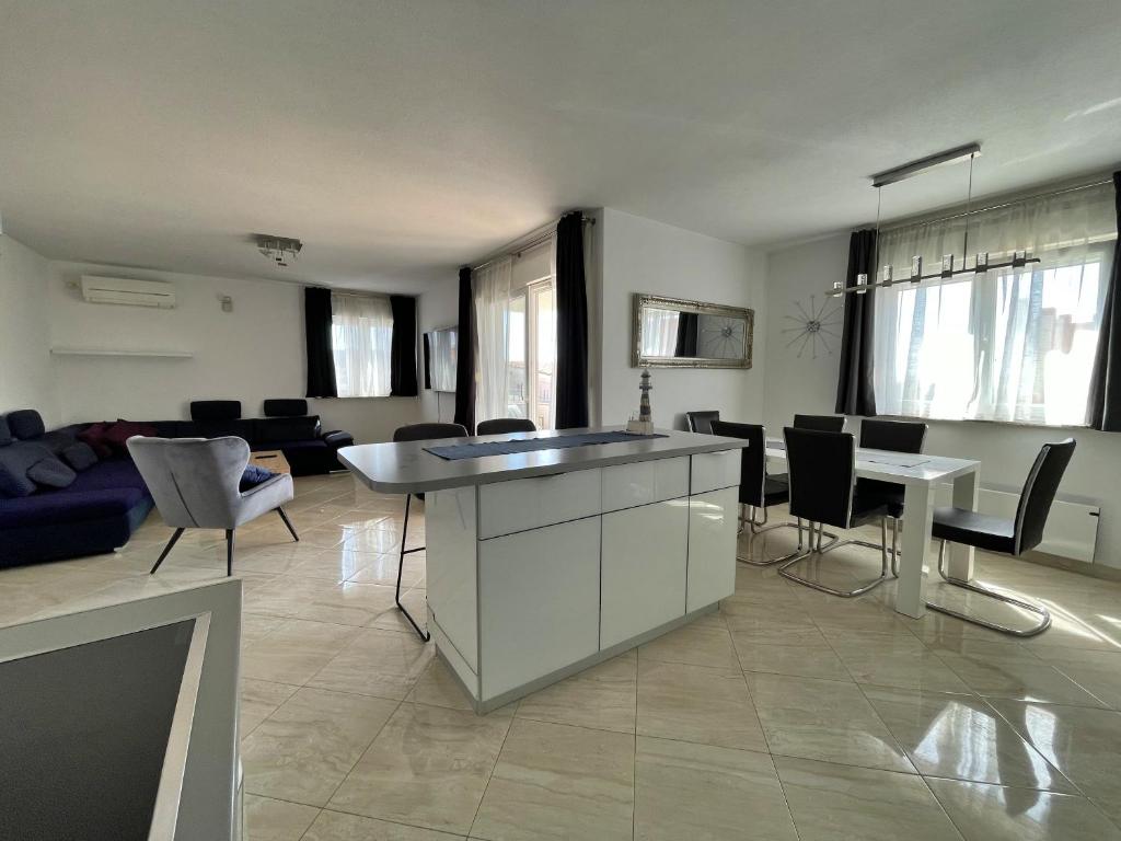 een keuken en een woonkamer met een tafel en stoelen bij Apartments Ursula 3 in Trogir