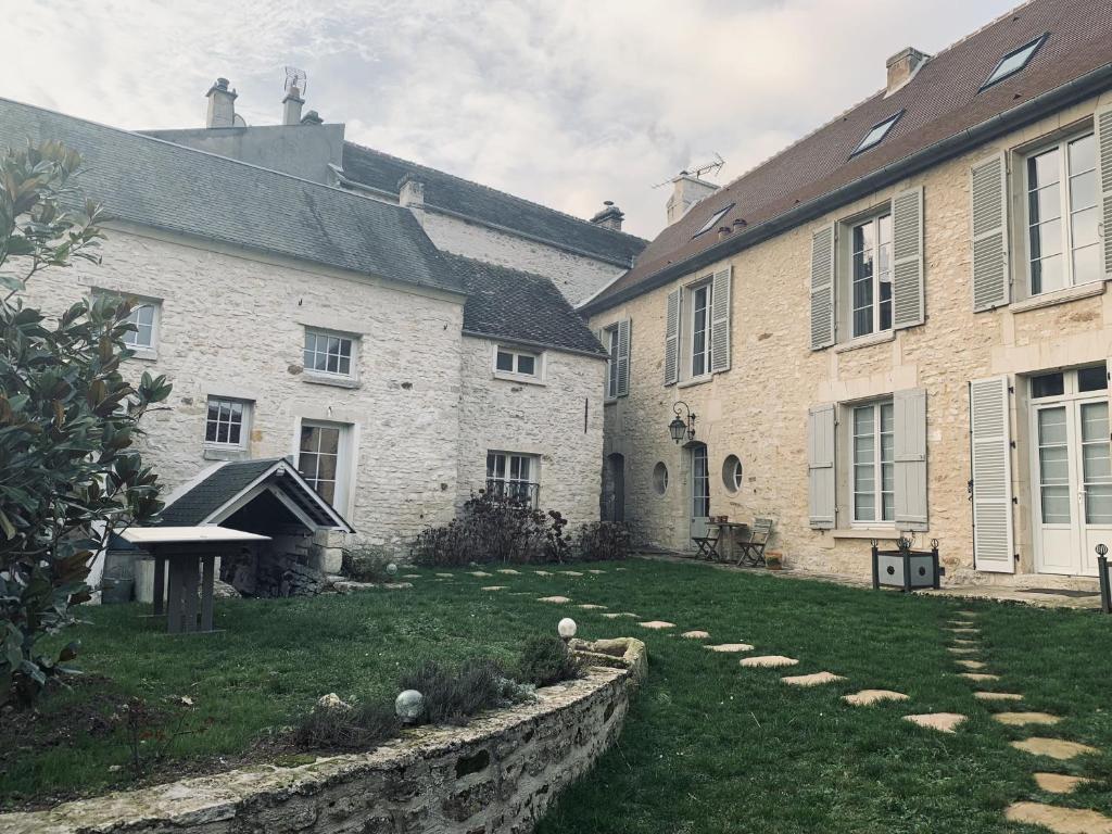 - un grand bâtiment avec une cour devant dans l'établissement L'Annexe, à Génainville