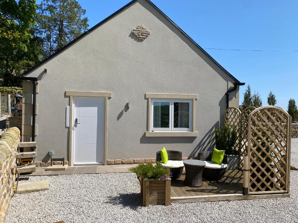 a house with a white door and a patio at The View, Luxury studio in Curbar
