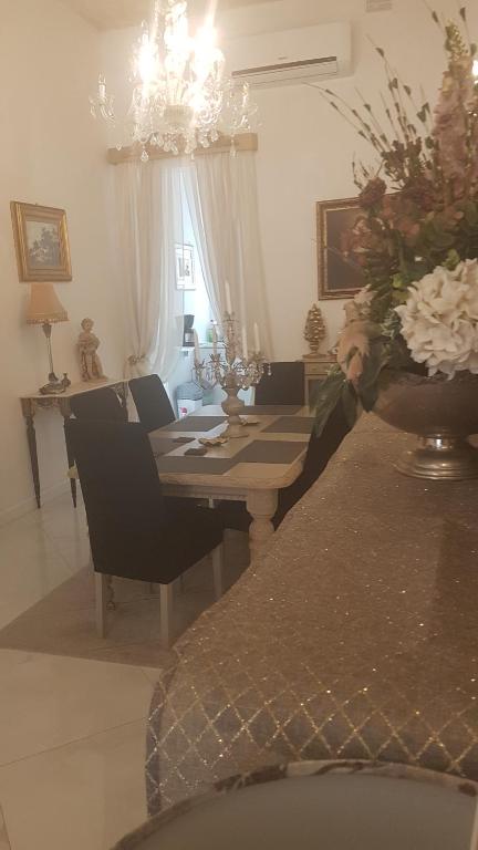 une salle à manger avec une table et un vase de fleurs dans l'établissement St Gabriel's, à Tarxien