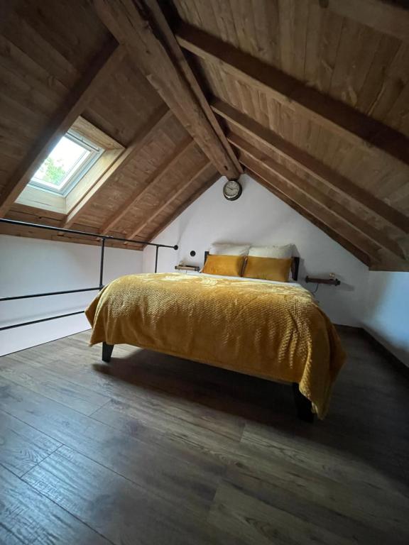 1 dormitorio con cama amarilla en el ático en La Maison du Pere Pilon avec petit dejeuner en Auvers-sur-Oise