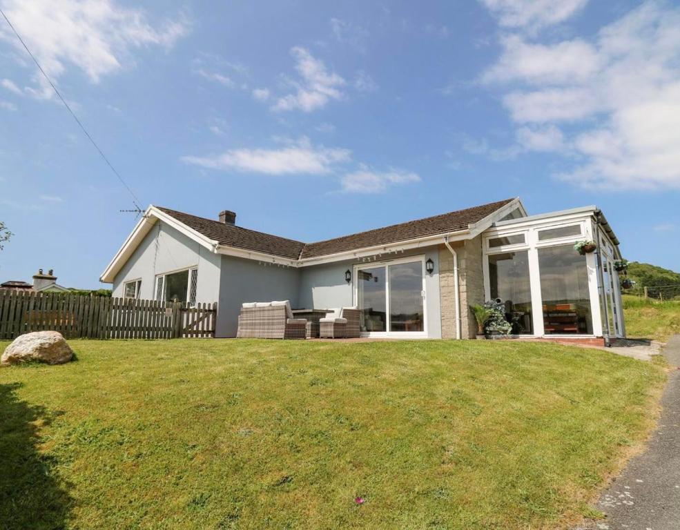 a house with a large lawn in front of it at Aberceiro Bungalow in Aberystwyth