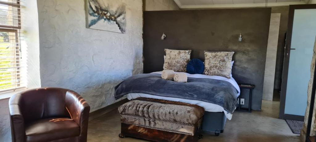 um quarto com uma cama e uma cadeira em La Vista Farm Stay em Ermelo