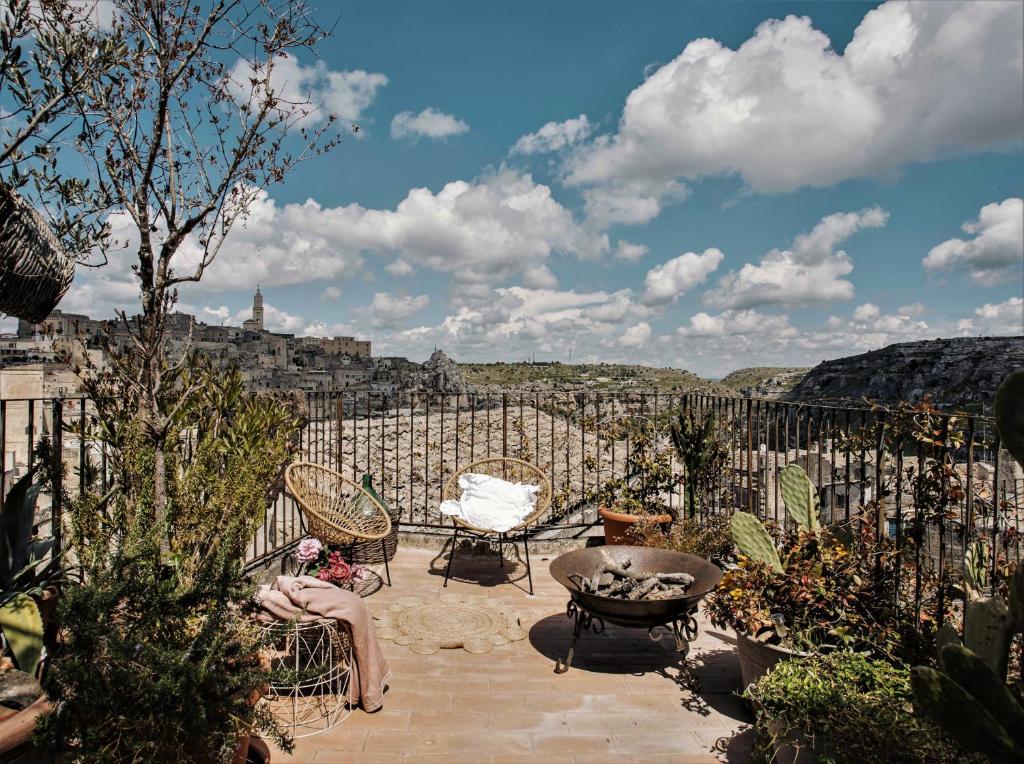a woman sitting on a patio with a view of the city at Corte San Leonardo in Matera