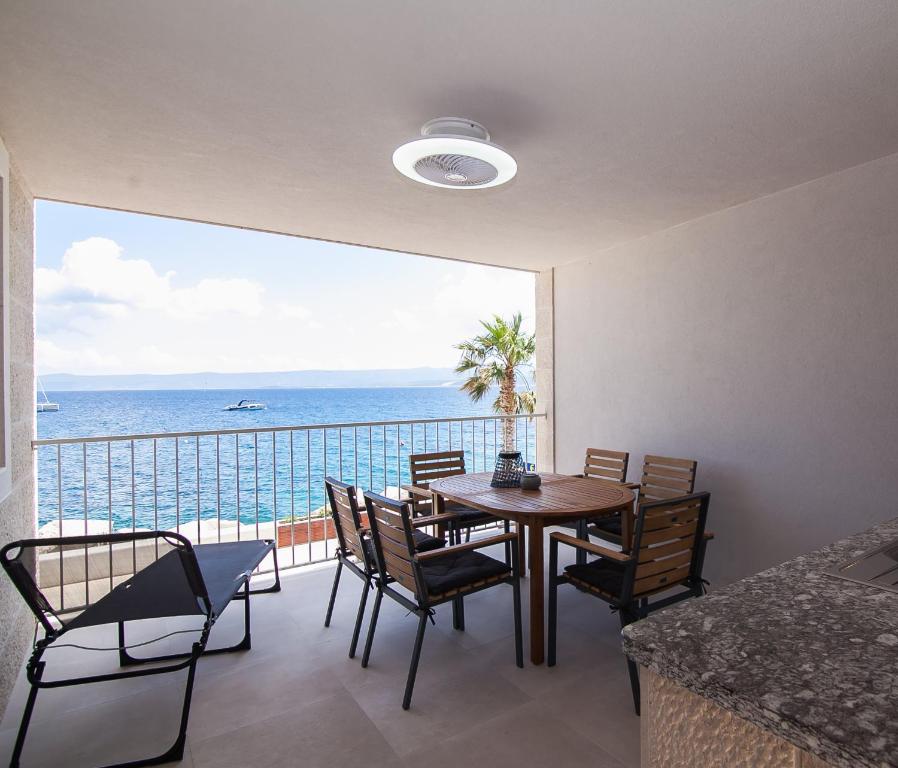 a dining room with a table and chairs and the ocean at Apartment CasArosa in Bol