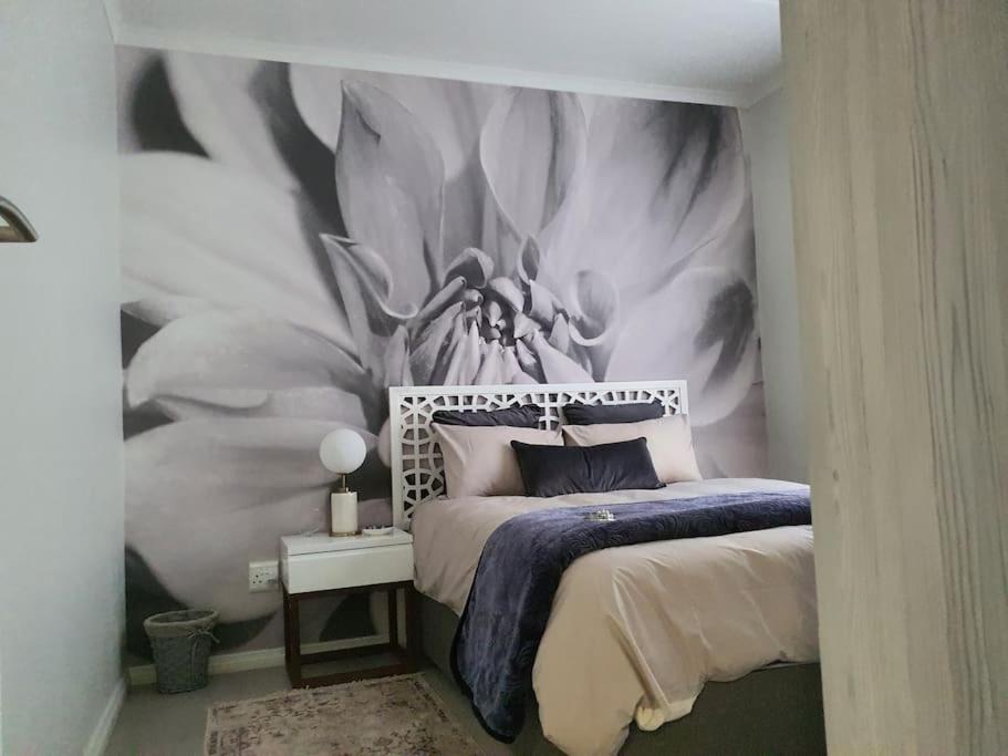 um quarto com uma cama e uma parede com um mural de veado em City Slick at 92 on Stylish Apartment in Carlswald em Midrand