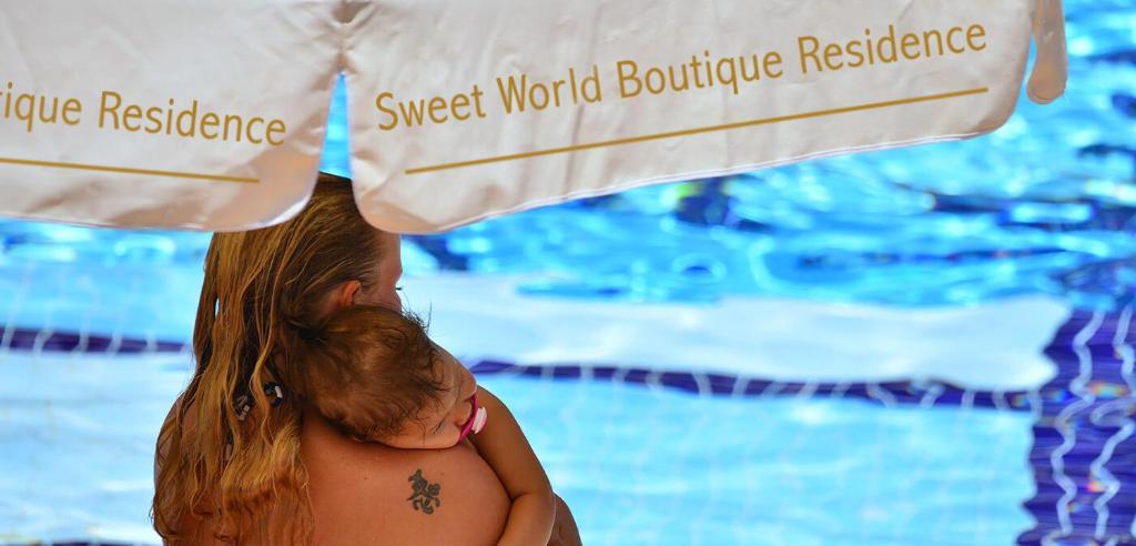 a woman with a tattoo on her back next to a swimming pool at A dreamy luxury one-bedroom apartment with special views of the forest, sea and sunset in Alanya