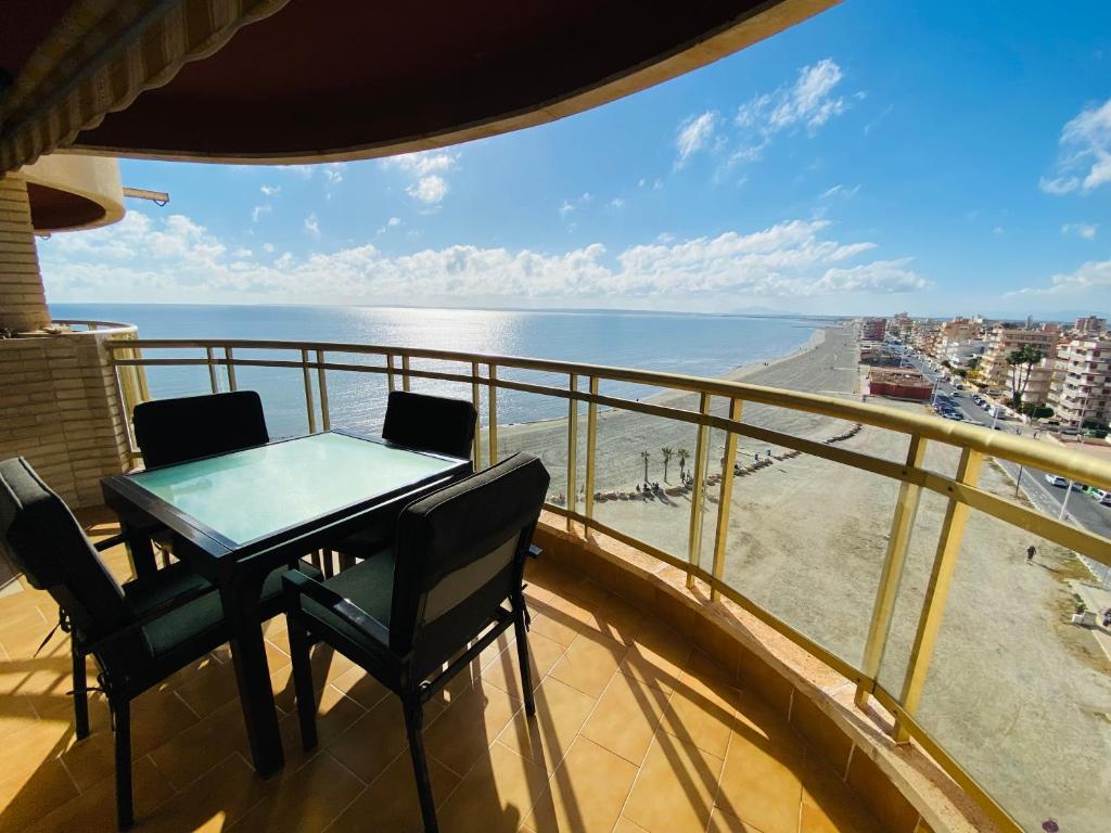 einen Balkon mit einem Tisch, Stühlen und Meerblick in der Unterkunft Casa Don Juan in Santa Pola