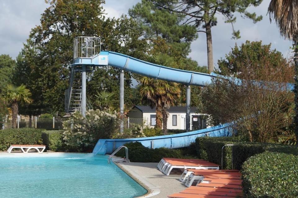 a swimming pool with a water slide in a yard at Mobilhome tout confort les viviers in Lège-Cap-Ferret