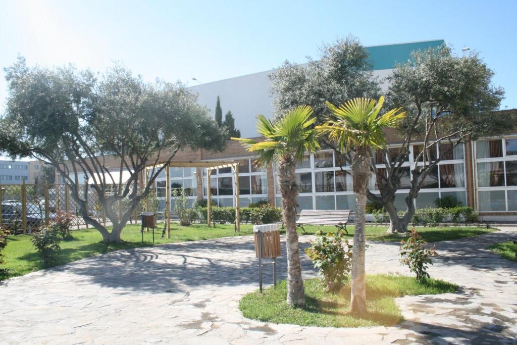 a building with trees in front of it at Hotel El Águila in Utebo