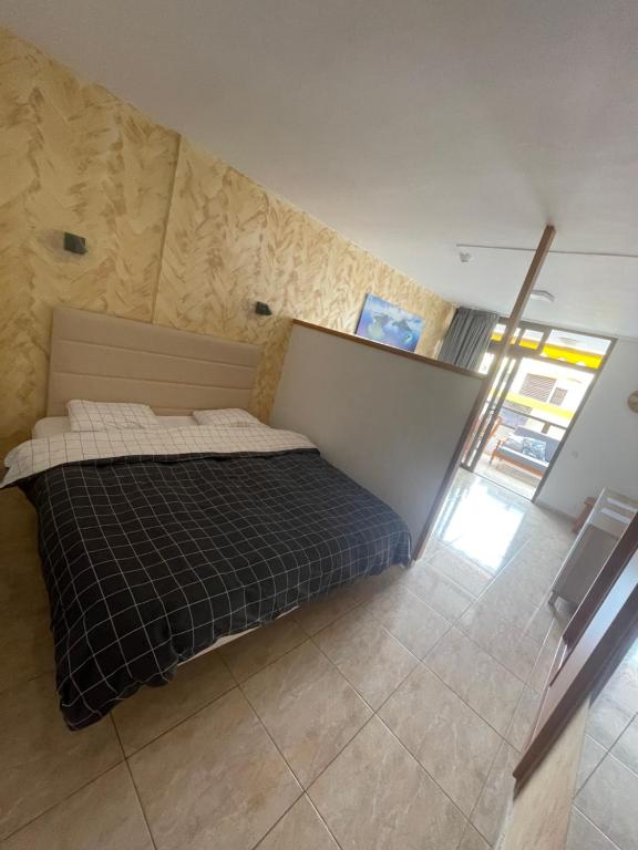 a bedroom with a bed with a black blanket at Apartament Modern 1 Playa del Ingles in San Bartolomé